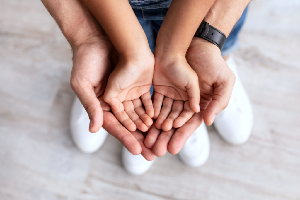 Closeup of father and daughter holding hands